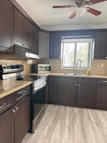 a kitchen with a sink stove and cabinets