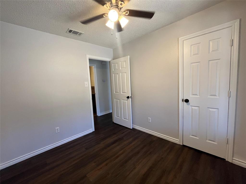 9644 Deer Park Road Quinlan, TX 75474 - Photo 17 of 25 an empty room with wooden floor and door