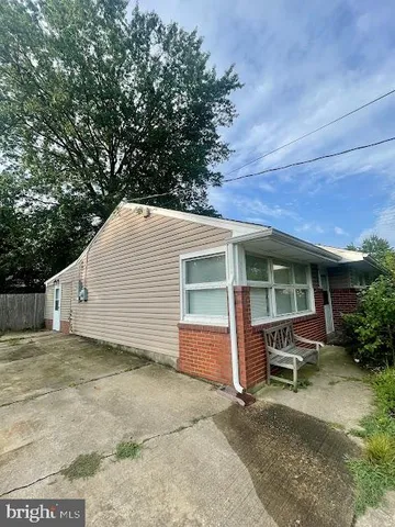 a view of a house with a patio and a yard