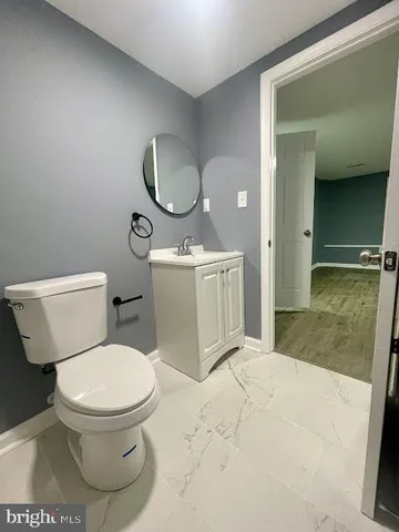 a bathroom with a toilet a sink and mirror