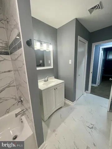 a bathroom with a sink mirror and shower