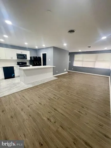 a view of kitchen with stainless steel appliances wooden floor