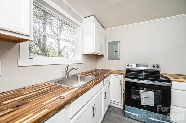 a kitchen with a stove a sink and a window