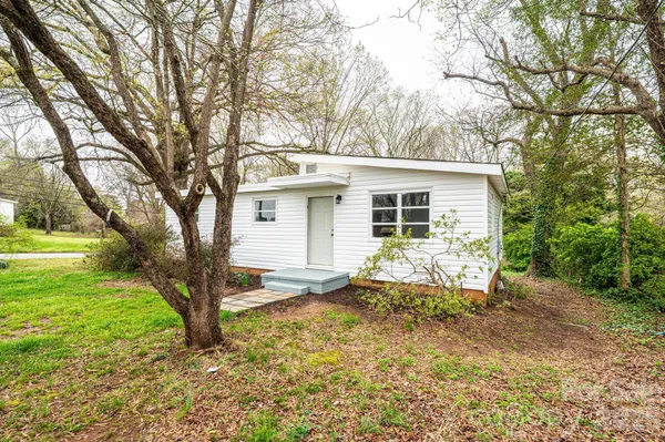 a backyard of a house with table and chairs