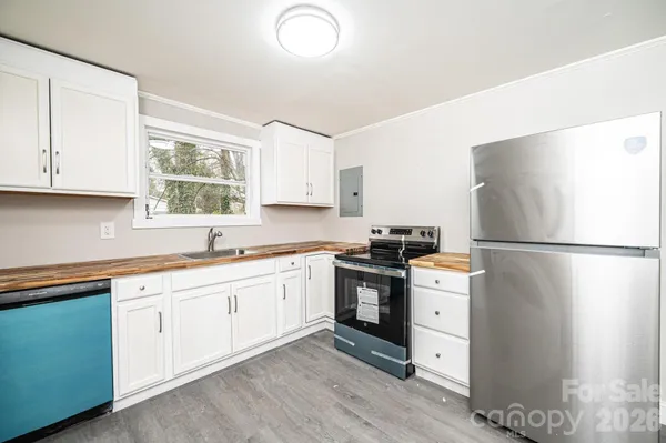 a kitchen with stainless steel appliances granite countertop a refrigerator sink and stove