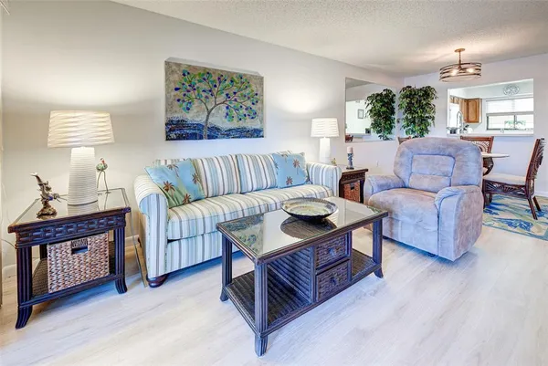 a living room with furniture a wooden floor and a large window