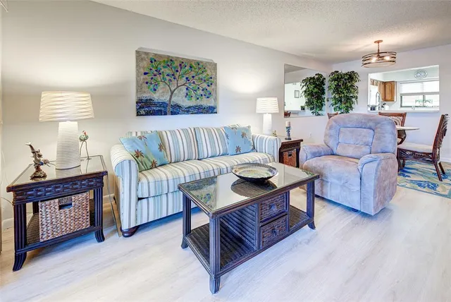 a living room with furniture a wooden floor and a large window