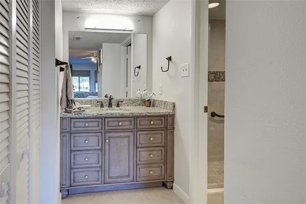 a bathroom with a granite countertop sink toilet and shower