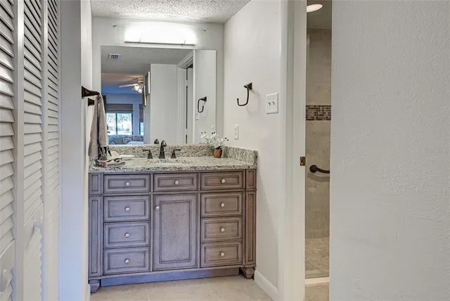 a bathroom with a granite countertop sink toilet and shower