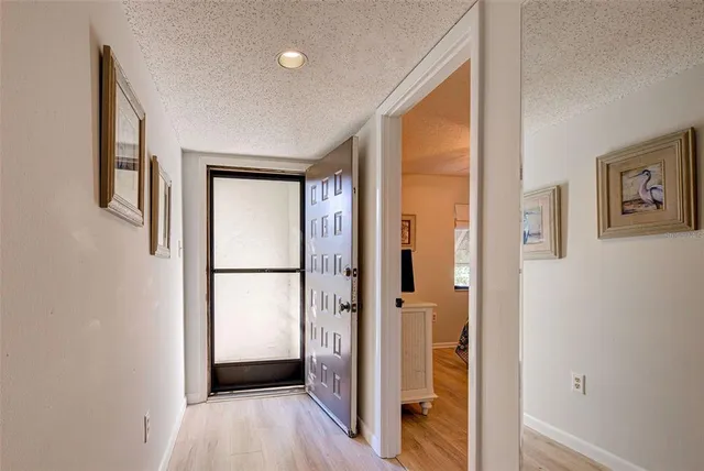 a view of a hallway with wooden floor and closet