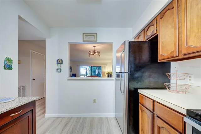 a kitchen with stainless steel appliances granite countertop a refrigerator and a sink