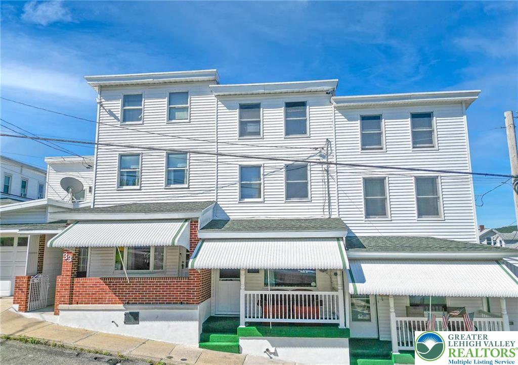 a front view of a residential apartment building with a yard