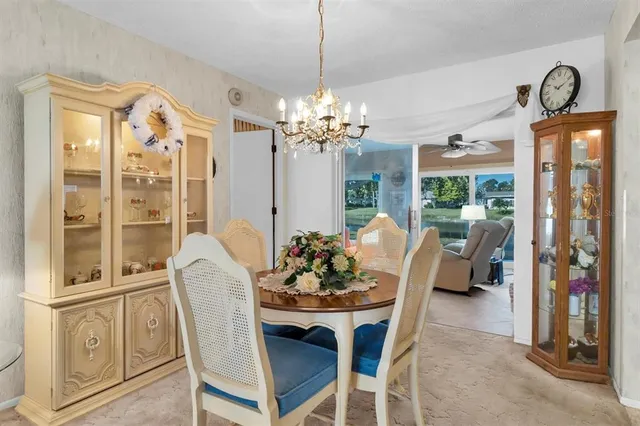 a dining room with furniture a chandelier and window
