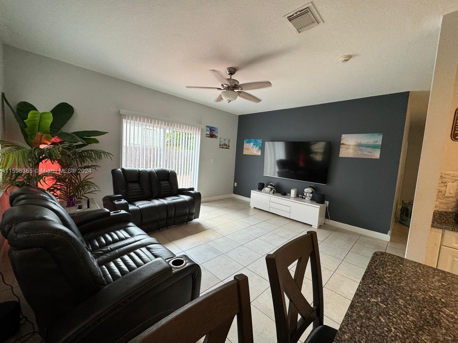 2841 Northeast 41st Place Homestead, FL 33033 - Photo 7 of 71 a living room with furniture a flat screen tv and a table