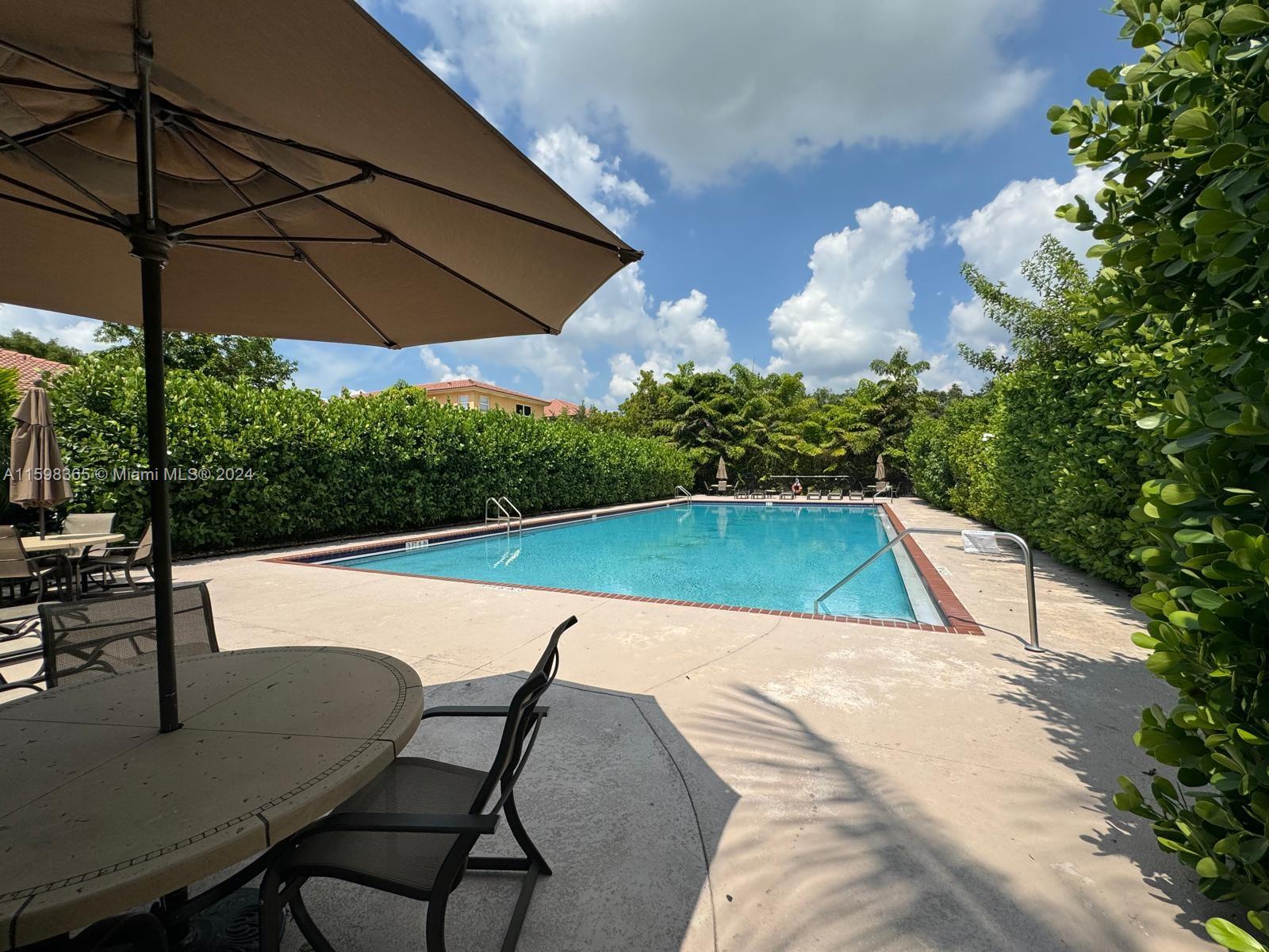 2841 Northeast 41st Place Homestead, FL 33033 - Photo 71 of 71 a view of pool with lawn chairs under an umbrella