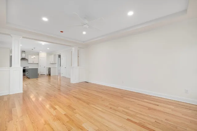 a view of an empty room and kitchen view