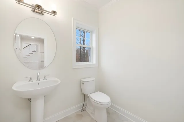 a bathroom with a toilet a sink and mirror