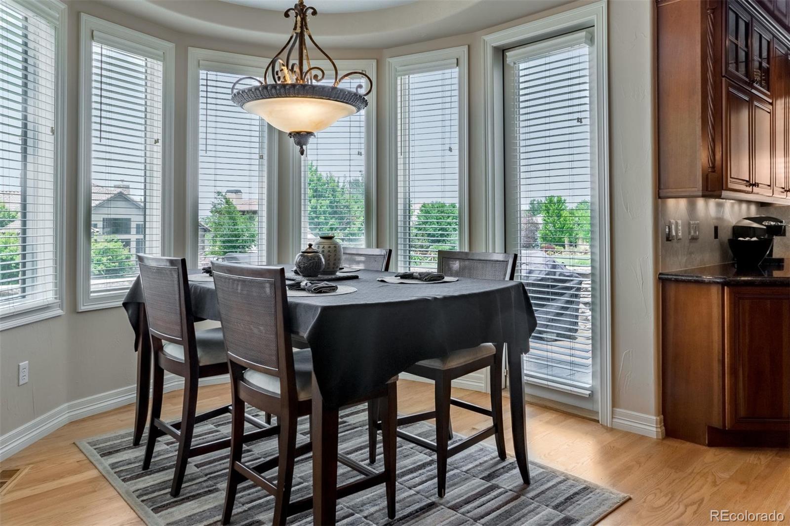 2671 Ranch Reserve Ridge Westminster, CO 80234 - Photo 11 of 35 a dining room with furniture a chandelier and wooden floor