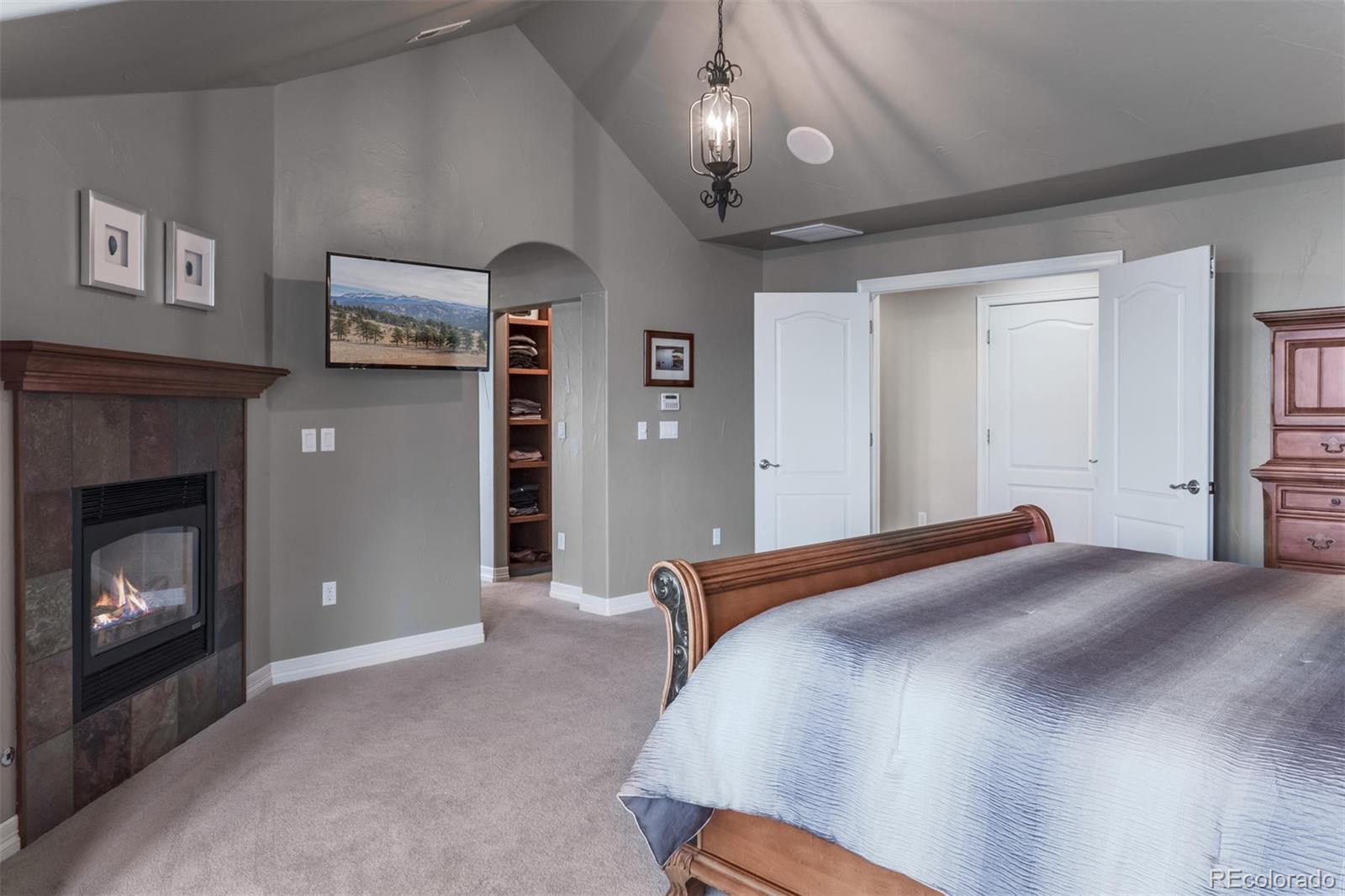 2671 Ranch Reserve Ridge Westminster, CO 80234 - Photo 17 of 35 a bedroom with a bed and a fireplace