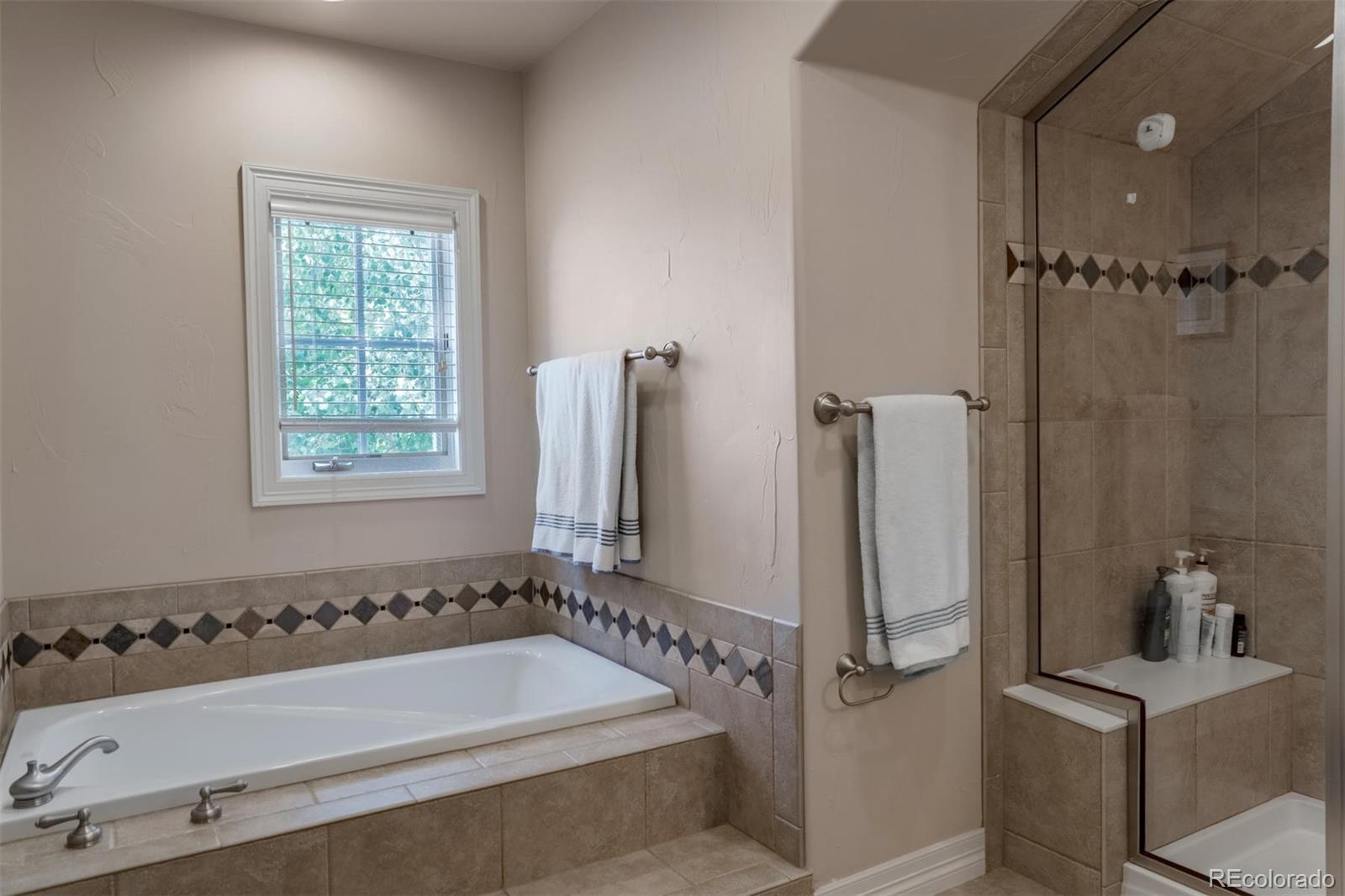 2671 Ranch Reserve Ridge Westminster, CO 80234 - Photo 21 of 35 a bathroom with a tub a sink and a window