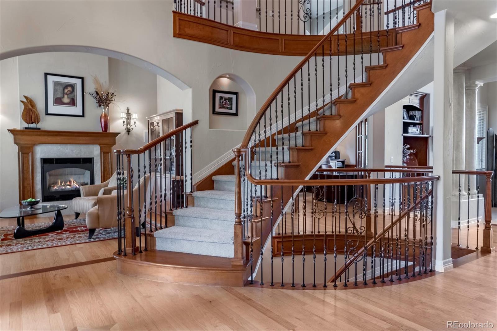 2671 Ranch Reserve Ridge Westminster, CO 80234 - Photo 4 of 35 a view of staircase with wooden floor and a fireplace