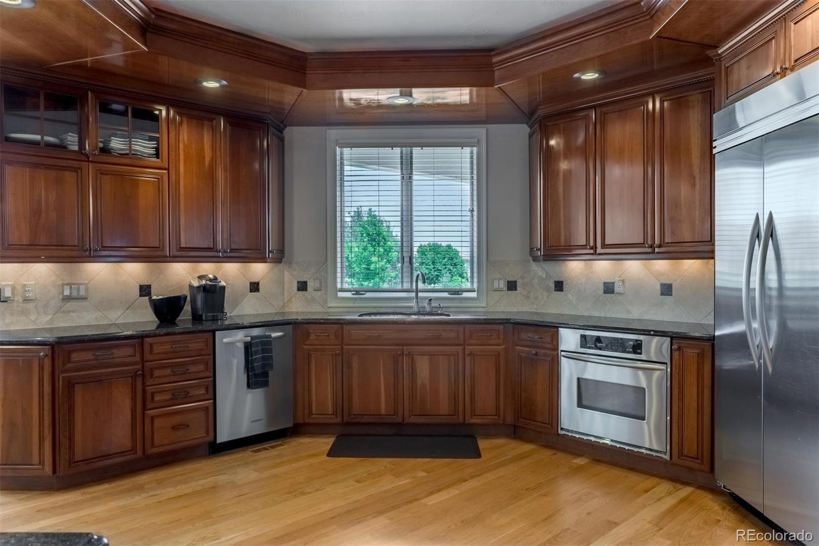 2671 Ranch Reserve Ridge Westminster, CO 80234 - Photo 9 of 35 a kitchen with stainless steel appliances granite countertop wooden cabinets a sink and a stove