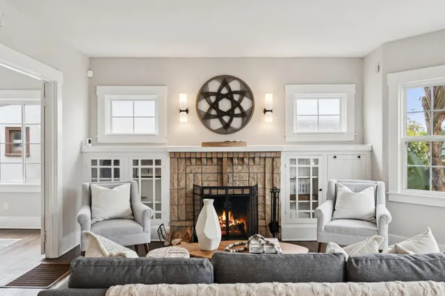 a living room with furniture a fireplace and a window