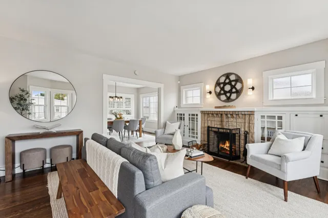 a living room with furniture a clock and a fireplace
