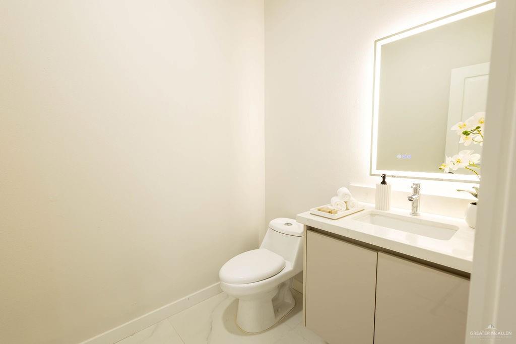 2209 Corales Street Mission, TX 78573 - Photo 13 of 30 a bathroom with a toilet a sink and mirror
