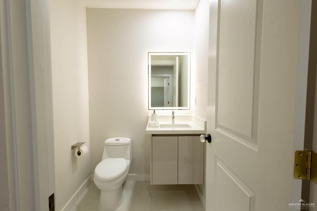 2209 Corales Street Mission, TX 78573 - Photo 24 of 30 a bathroom with a toilet a sink and mirror