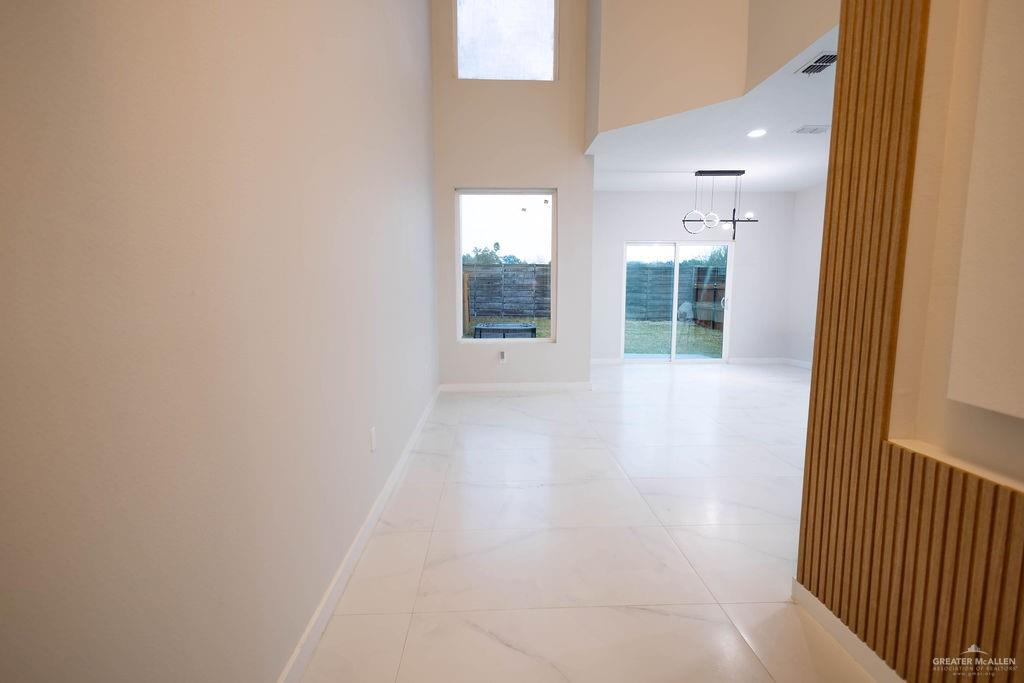 2209 Corales Street Mission, TX 78573 - Photo 4 of 30 a view of a hallway with wooden floor and a bathroom