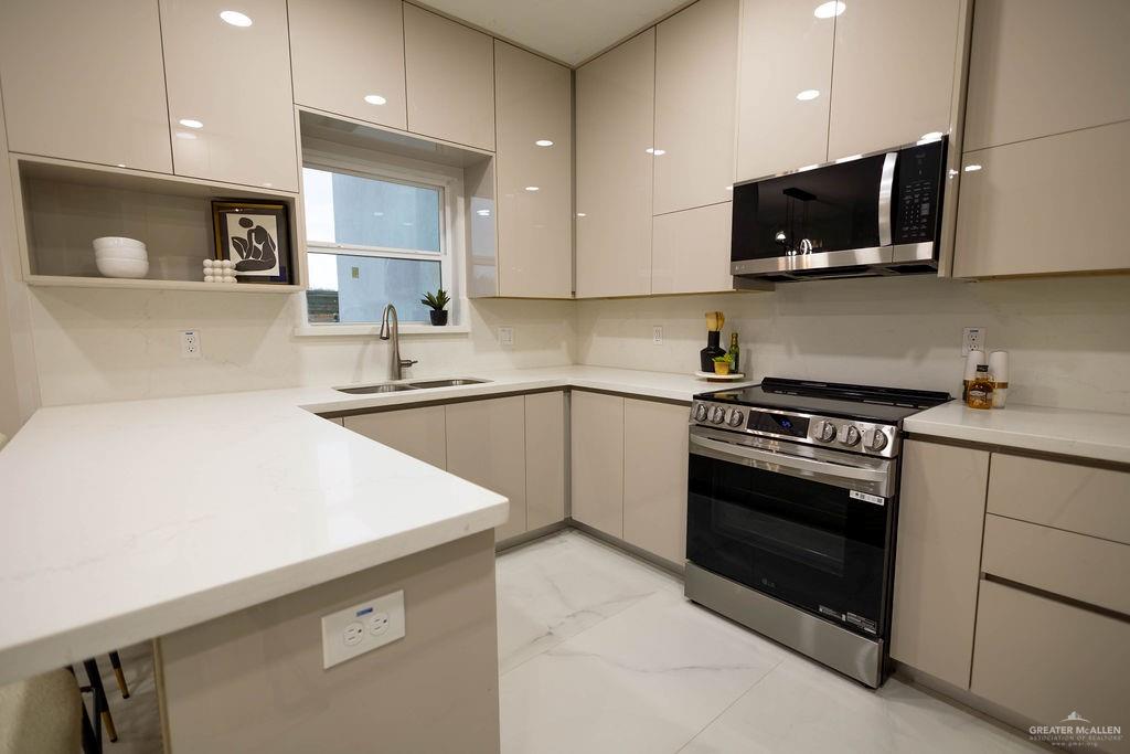 2209 Corales Street Mission, TX 78573 - Photo 9 of 30 a kitchen with stainless steel appliances a stove microwave and sink