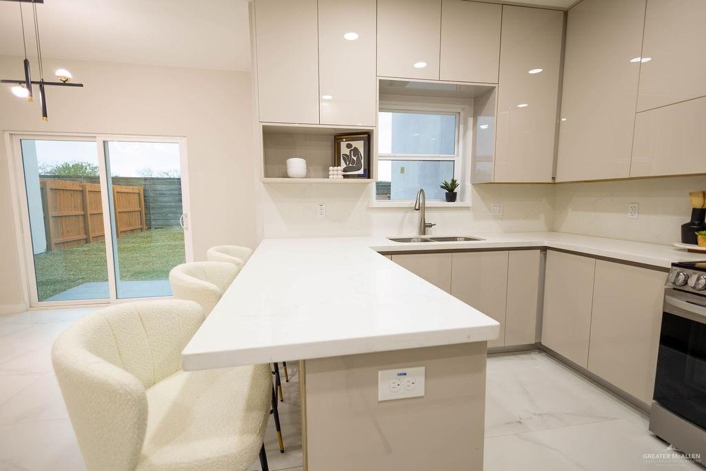 2209 Corales Street Mission, TX 78573 - Photo 10 of 30 a kitchen with a sink a kitchen island and stainless steel appliances