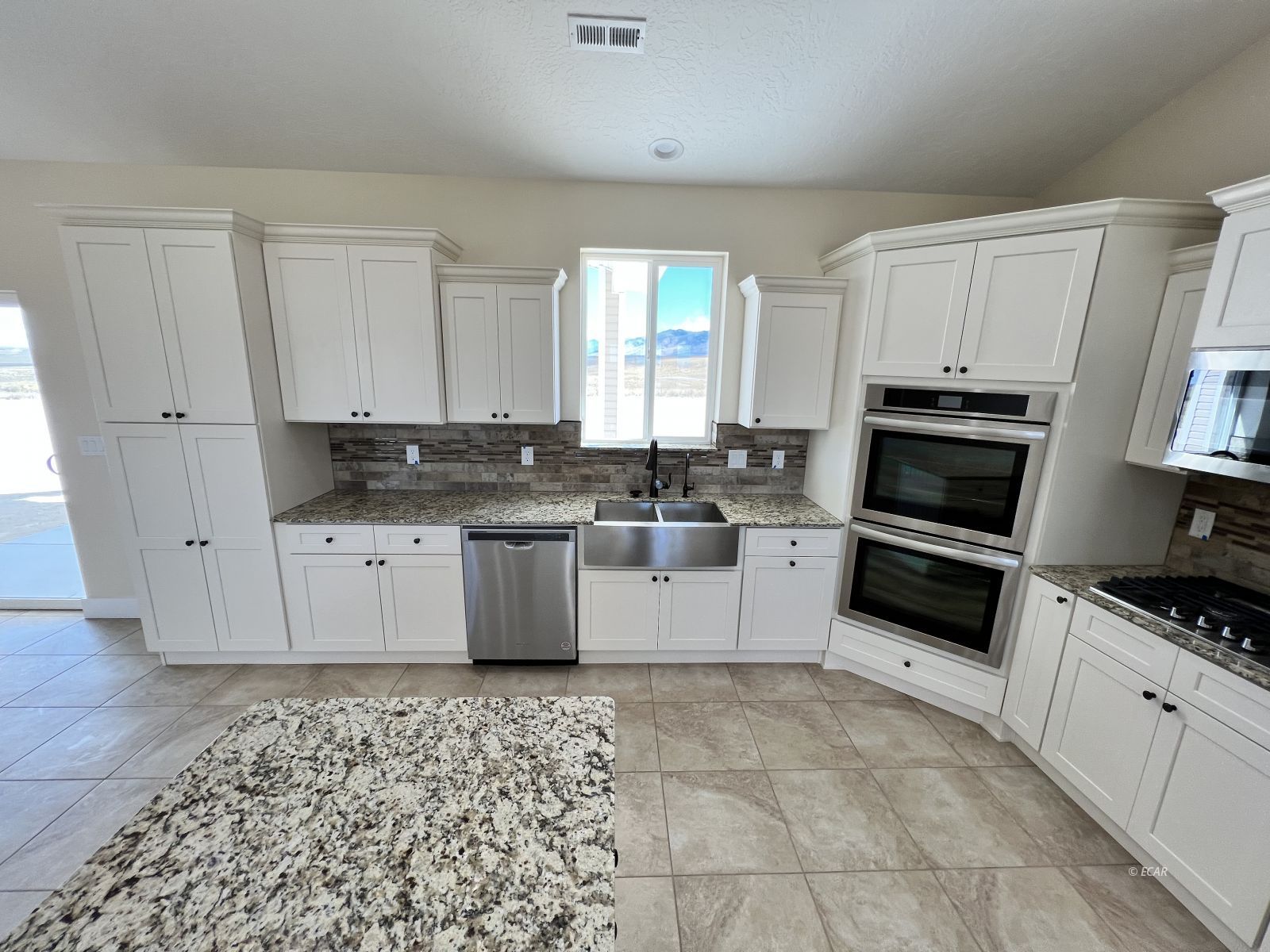 200 Ridgeway Drive Spring Creek, NV 89815 - Photo 14 of 34 a kitchen with granite countertop a stove sink and cabinets