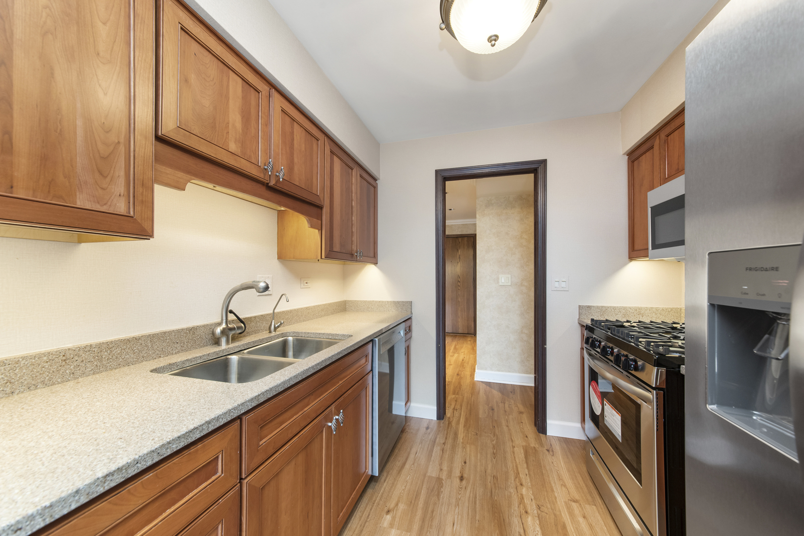 1-s150 Spring Road, Unit 2E Oak Brook, IL 60181 - Photo 4 of 22 a kitchen with a sink cabinets stainless steel appliances and a window
