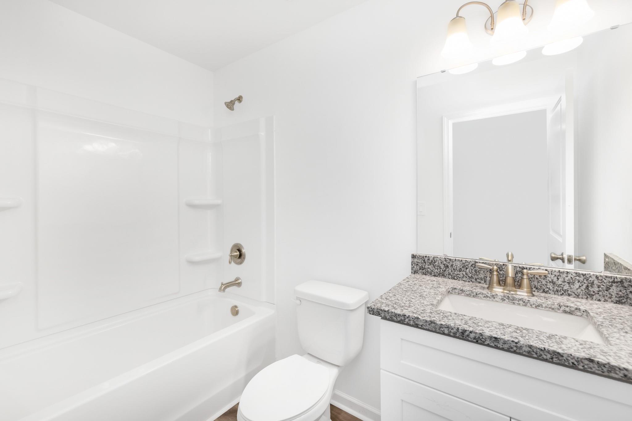 1076 Westminster Drive Lancaster, SC 29720 - Photo 13 of 19 a bathroom with a granite countertop sink a toilet and bathtub