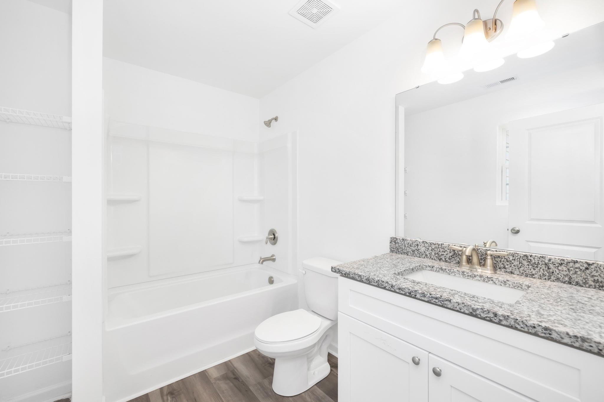 1076 Westminster Drive Lancaster, SC 29720 - Photo 15 of 19 a bathroom with a granite countertop sink a toilet and bathtub