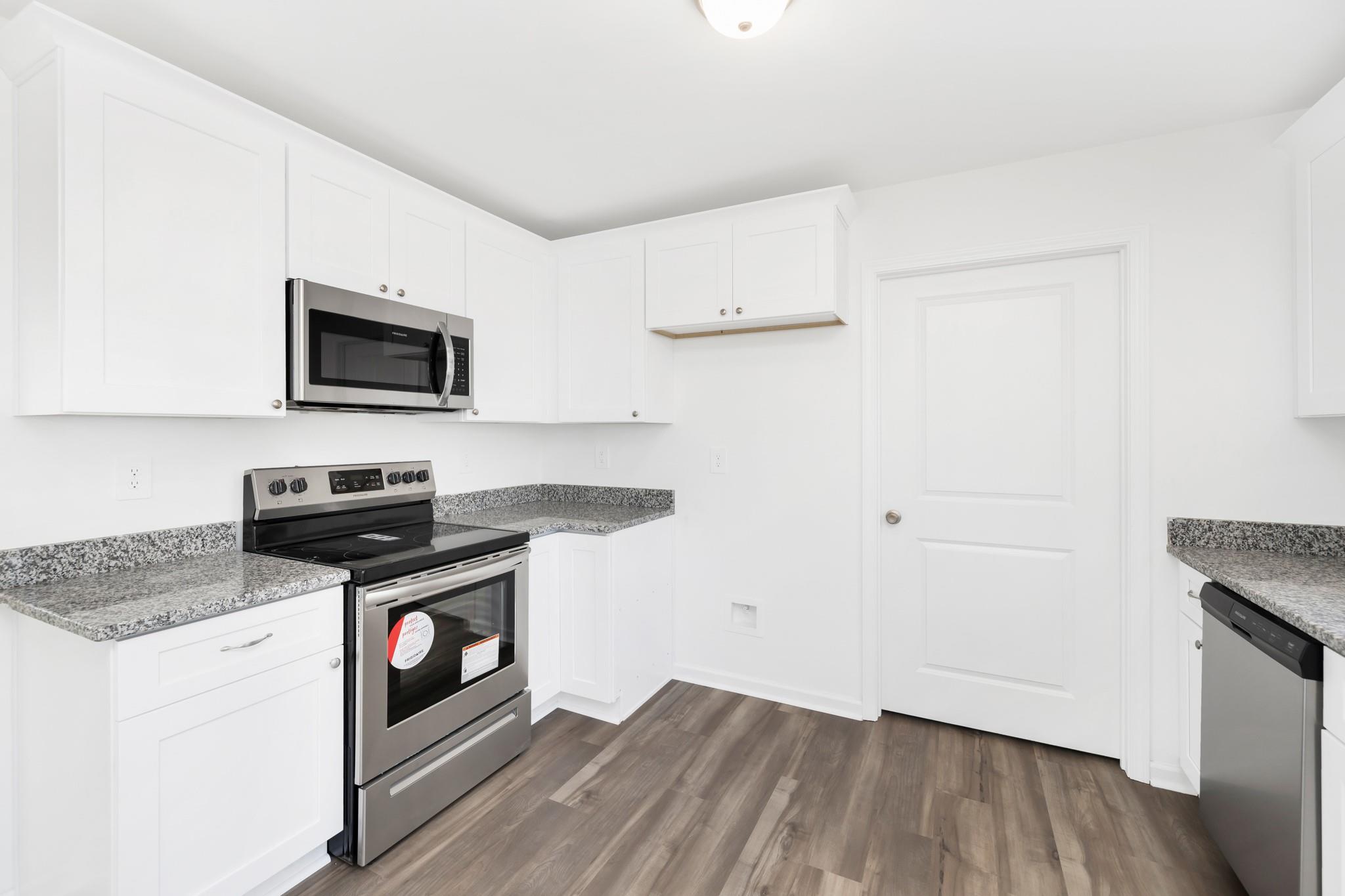 1076 Westminster Drive Lancaster, SC 29720 - Photo 7 of 19 a kitchen with granite countertop a stove and a wooden floor
