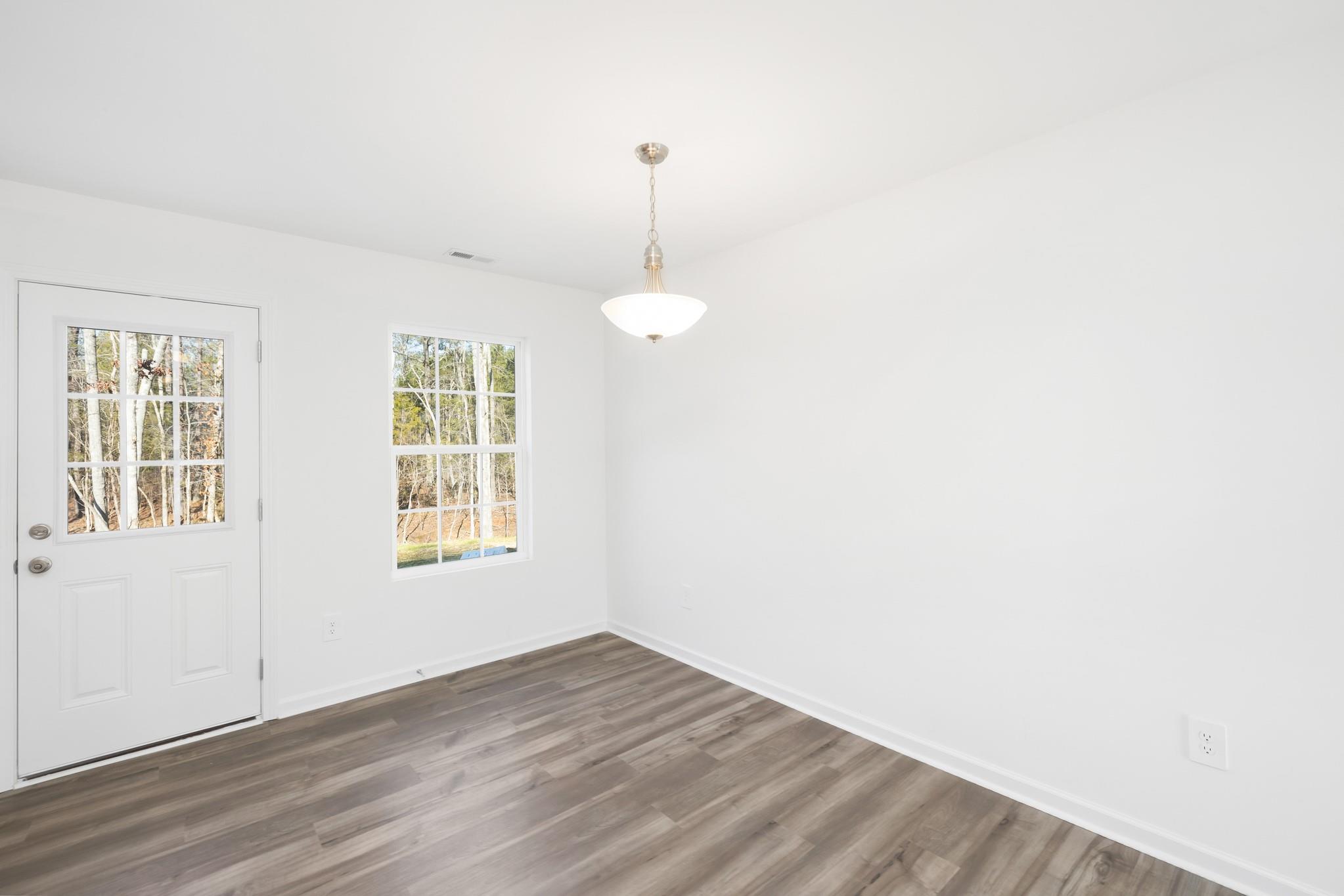 1076 Westminster Drive Lancaster, SC 29720 - Photo 9 of 19 a view of an empty room with wooden floor and a window