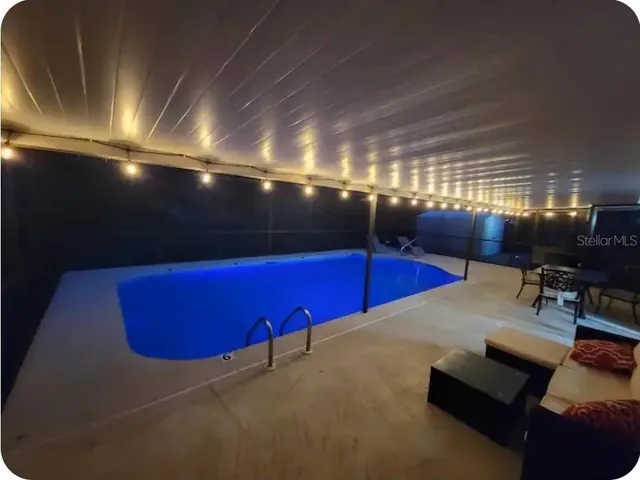 a living room with furniture wooden floor and a large window