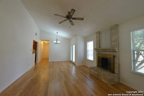 a view of empty room with fireplace and wooden floor