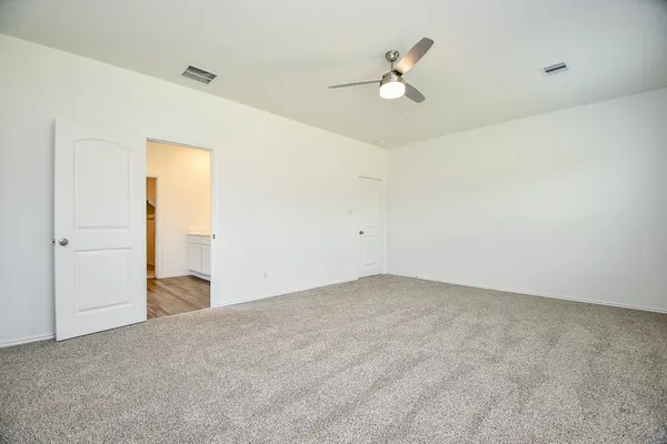 an empty room with closet and a ceiling fan