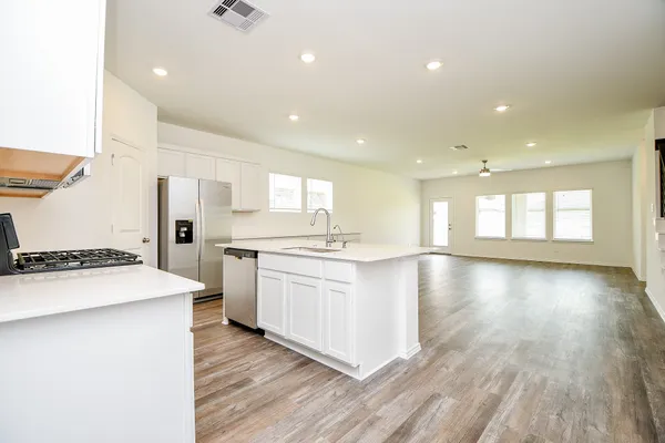 a large kitchen with stainless steel appliances kitchen island granite countertop a stove a sink and a refrigerator