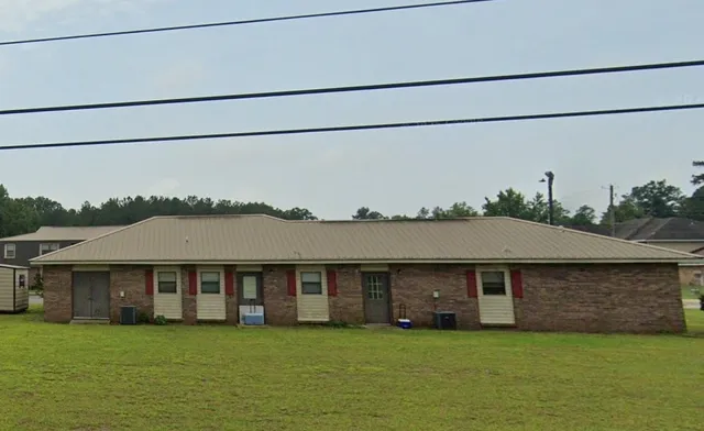 a view of a big house with a big yard and large trees