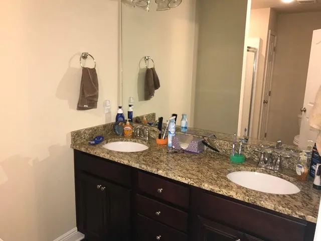 a bathroom with a granite countertop sink toilet and shower