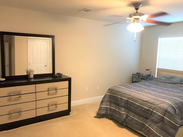 a bathroom with a granite countertop double vanity and a mirror