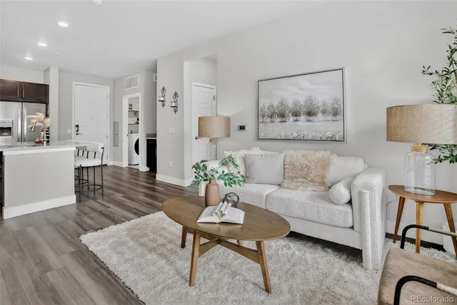 a living room with furniture a rug and a painting on the wall