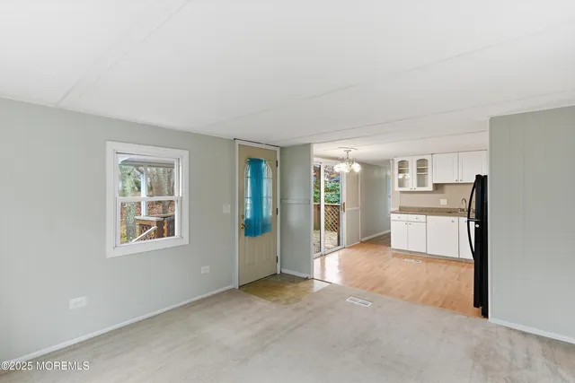 a view of a big room with kitchen and windows