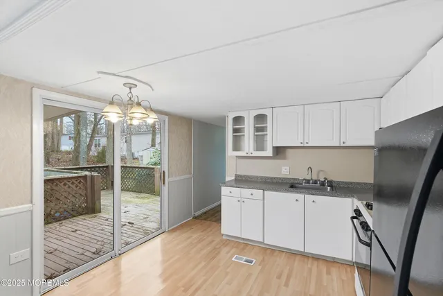 a kitchen with granite countertop a sink window and cabinets
