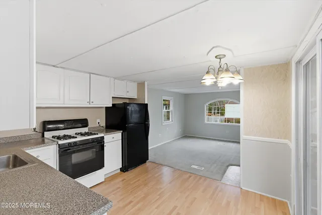 a kitchen with granite countertop a refrigerator and a stove top oven